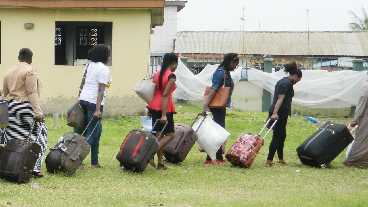 NYSC orientation camp entrance gate with corps members entering.