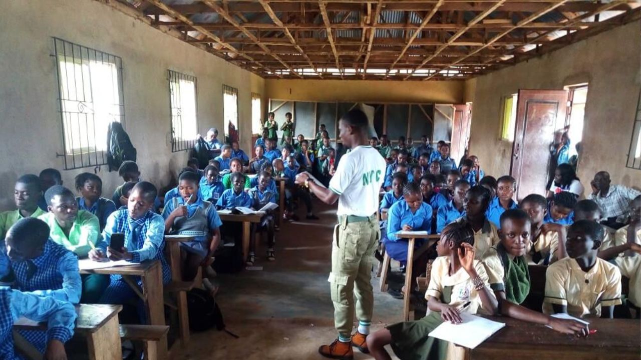 NYSC member teaching in a rural classroom (Engaged students, chalkboard)