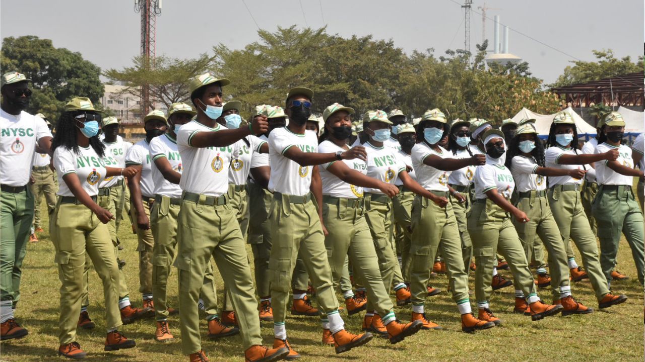 Group of corps members marching in a line during NYSC orientation.