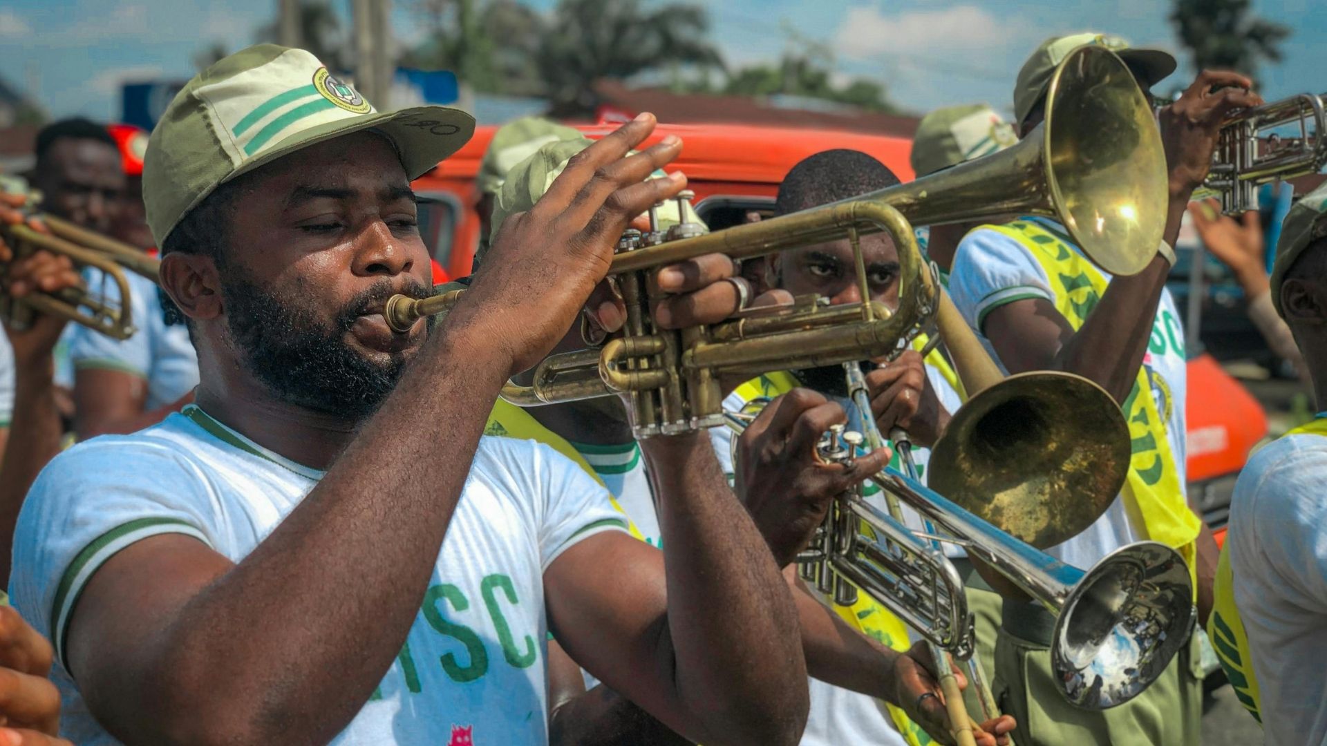 Close-up of an NYSC brass band, featuring corper musicians playing trumpets and other brass instruments.